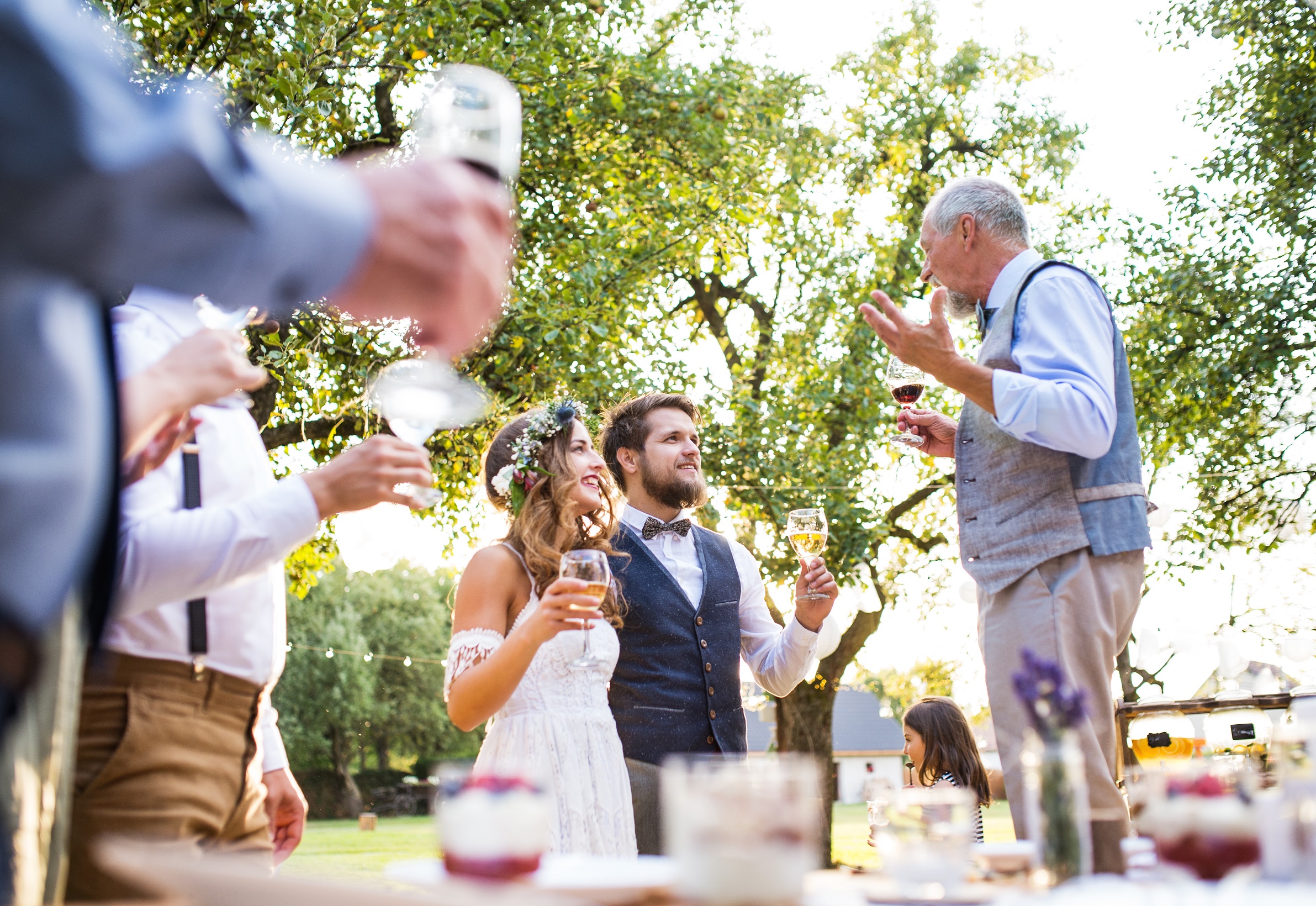 Elder man is talking with a newlyweds at party and making a toast.