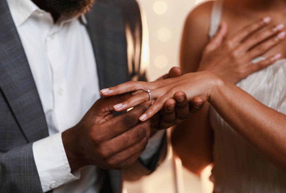 man in love putting wedding ring on his woman finger