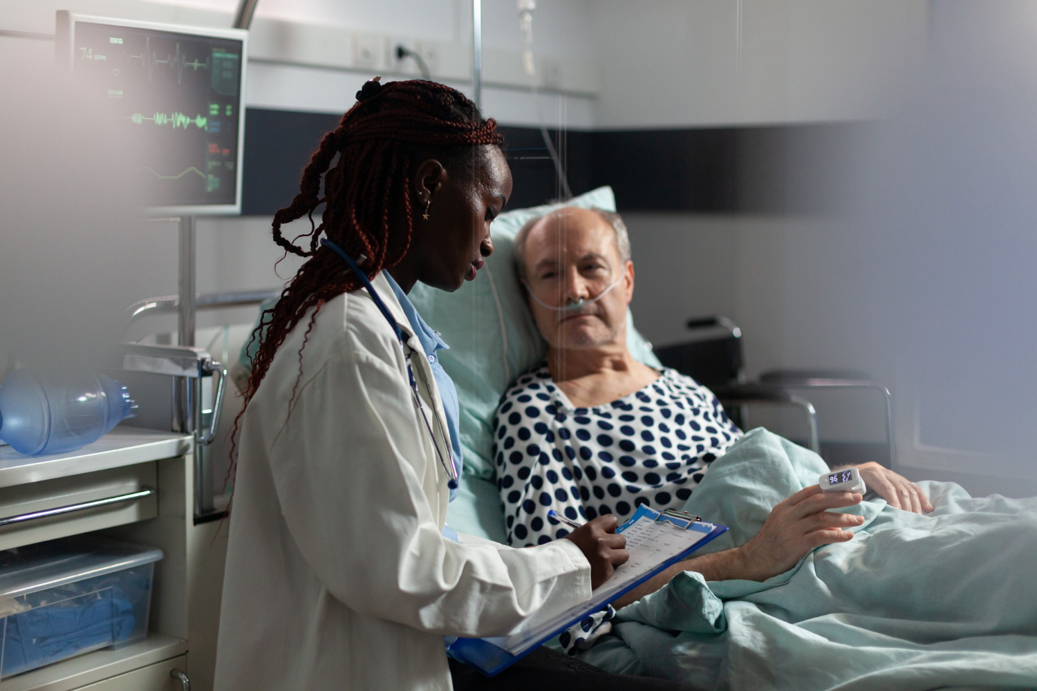 Young female doctor standing in hospital room discussing diagnosis with sick senior man.