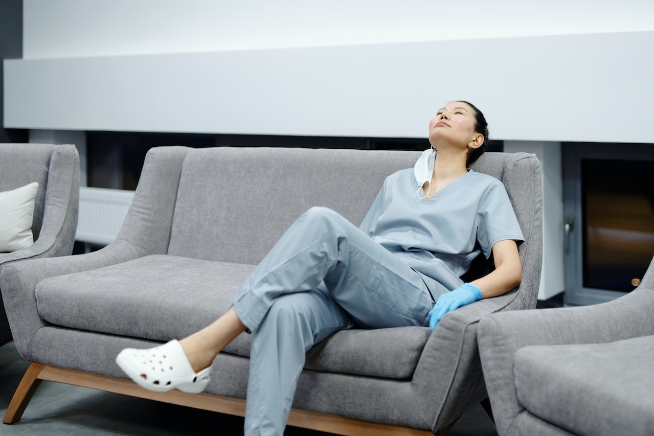 Female doctor in uniform is resting on the couch.