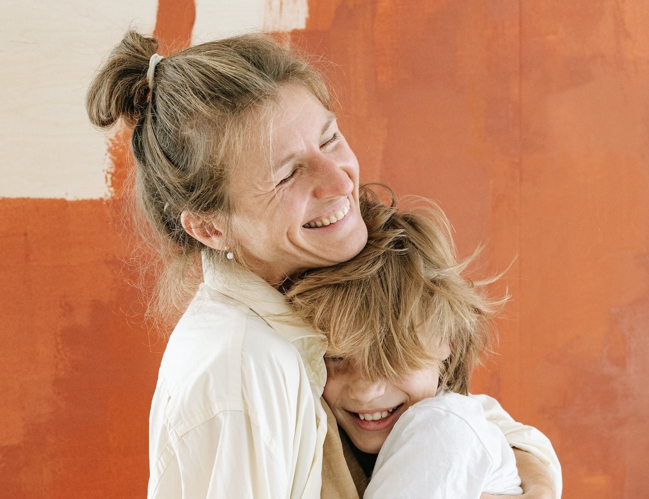 Mother is smiling and hugging her son.
