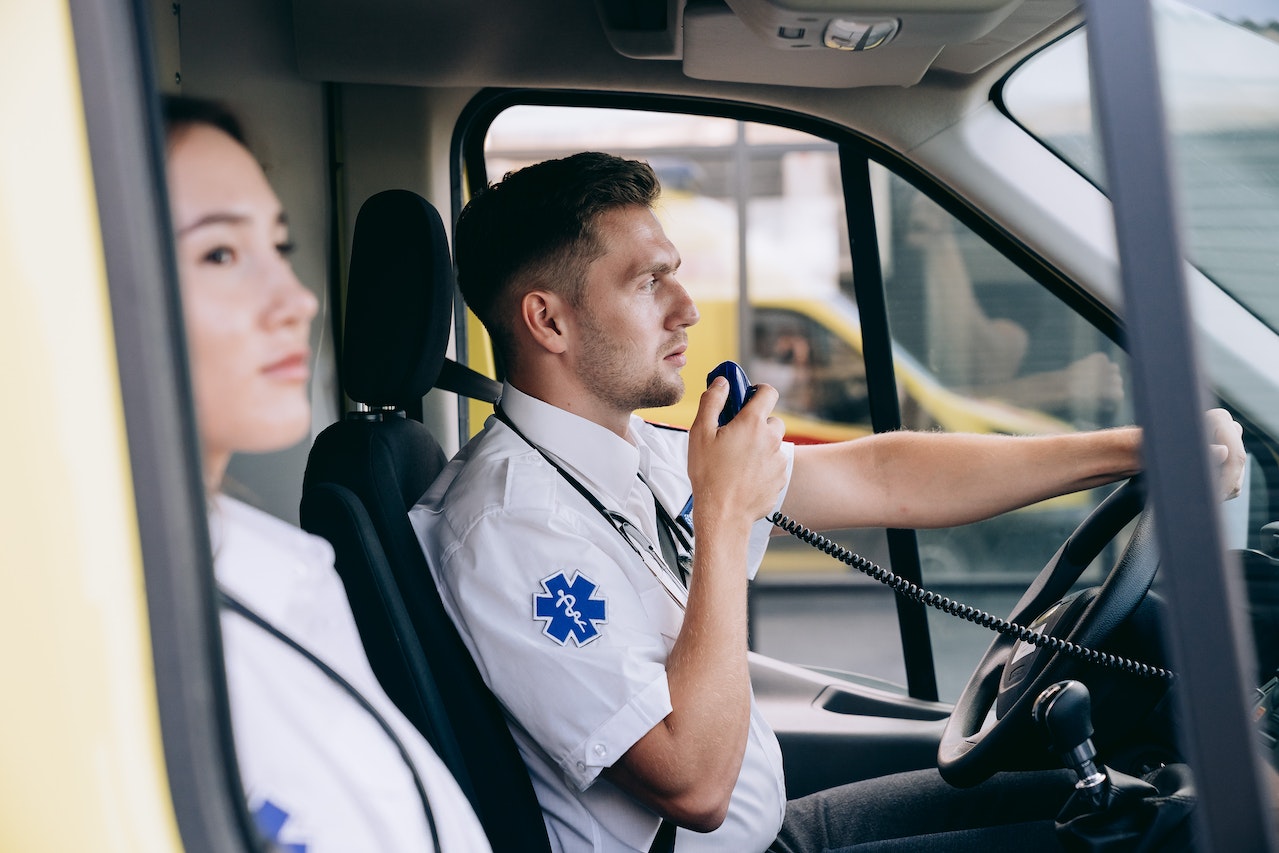 Paramedics using a radio inside an ambulance.