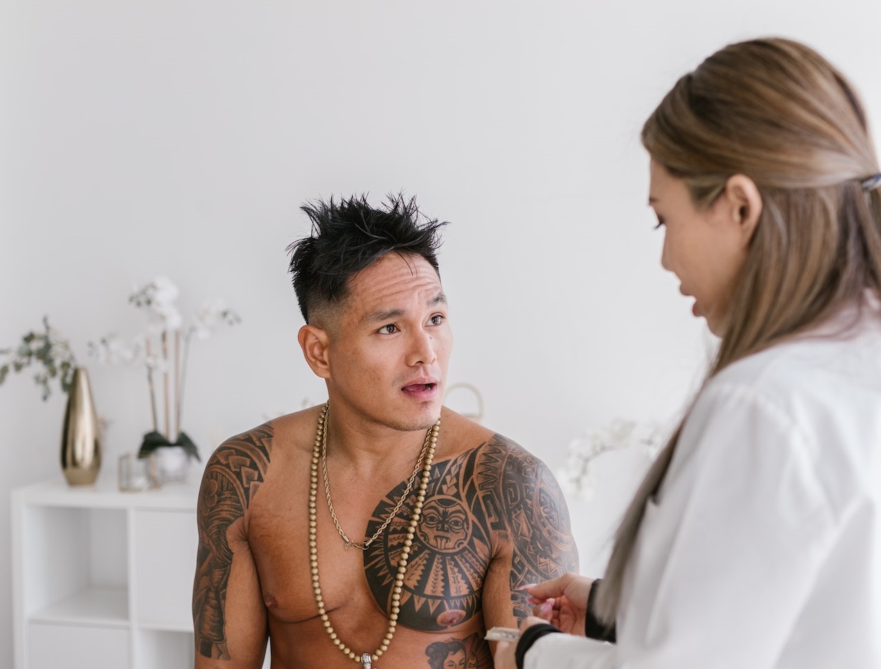 Man with tattoo talking to the female doctor.
