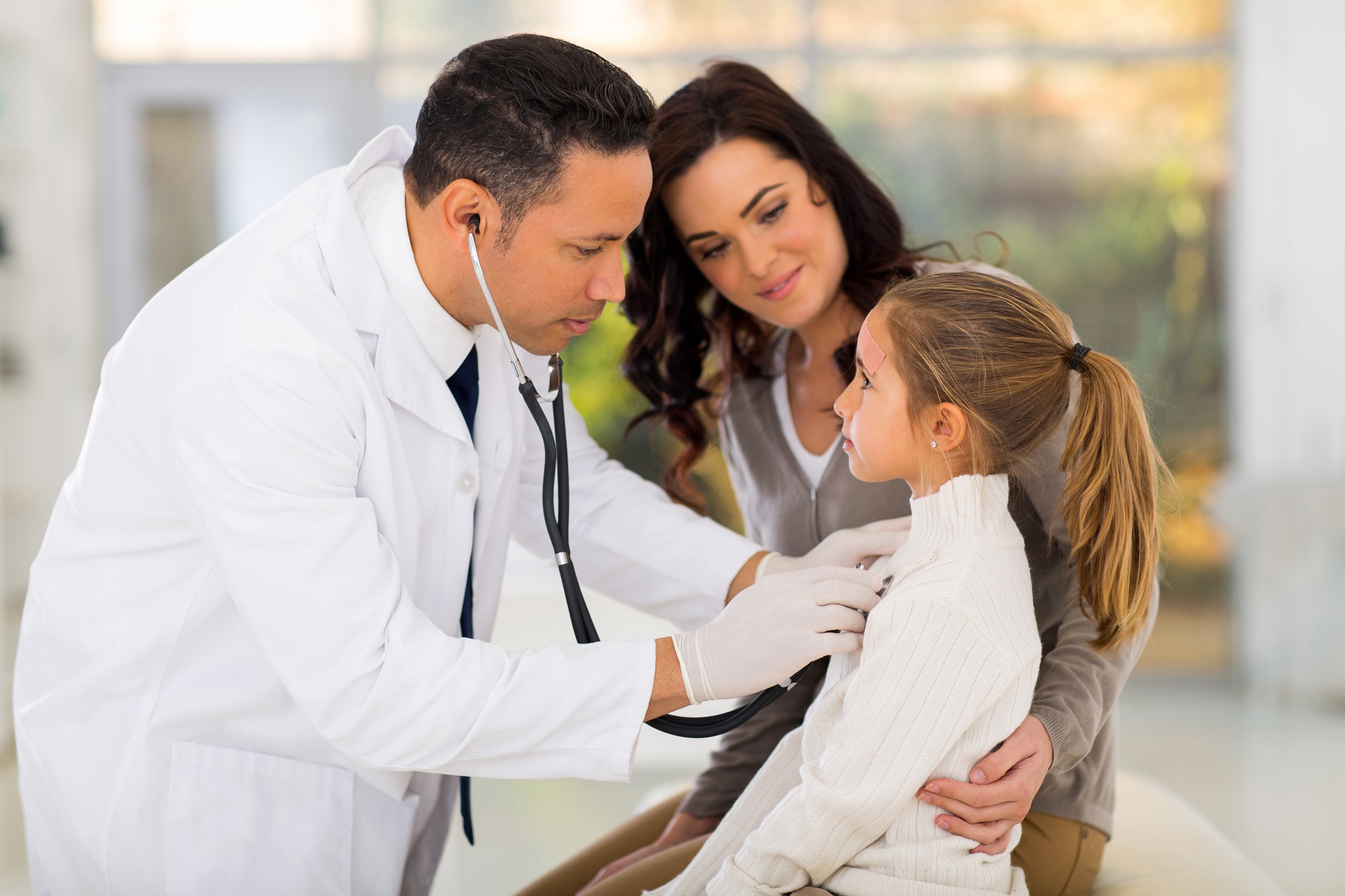 Doctor examining a little girl at hospital.