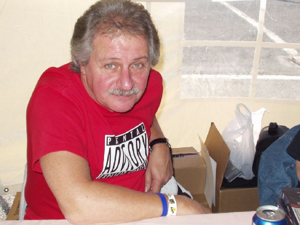 Ex-Beatles drummer Pete Best wearing red shirt and looking at camera
