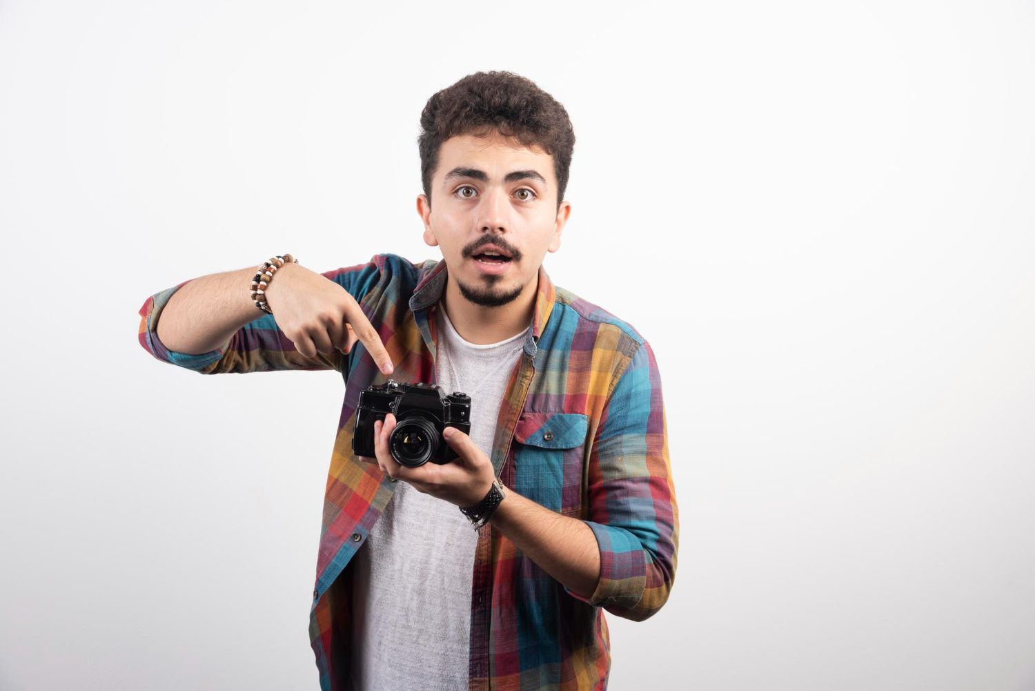 Young man is pointing to a photo camera.
