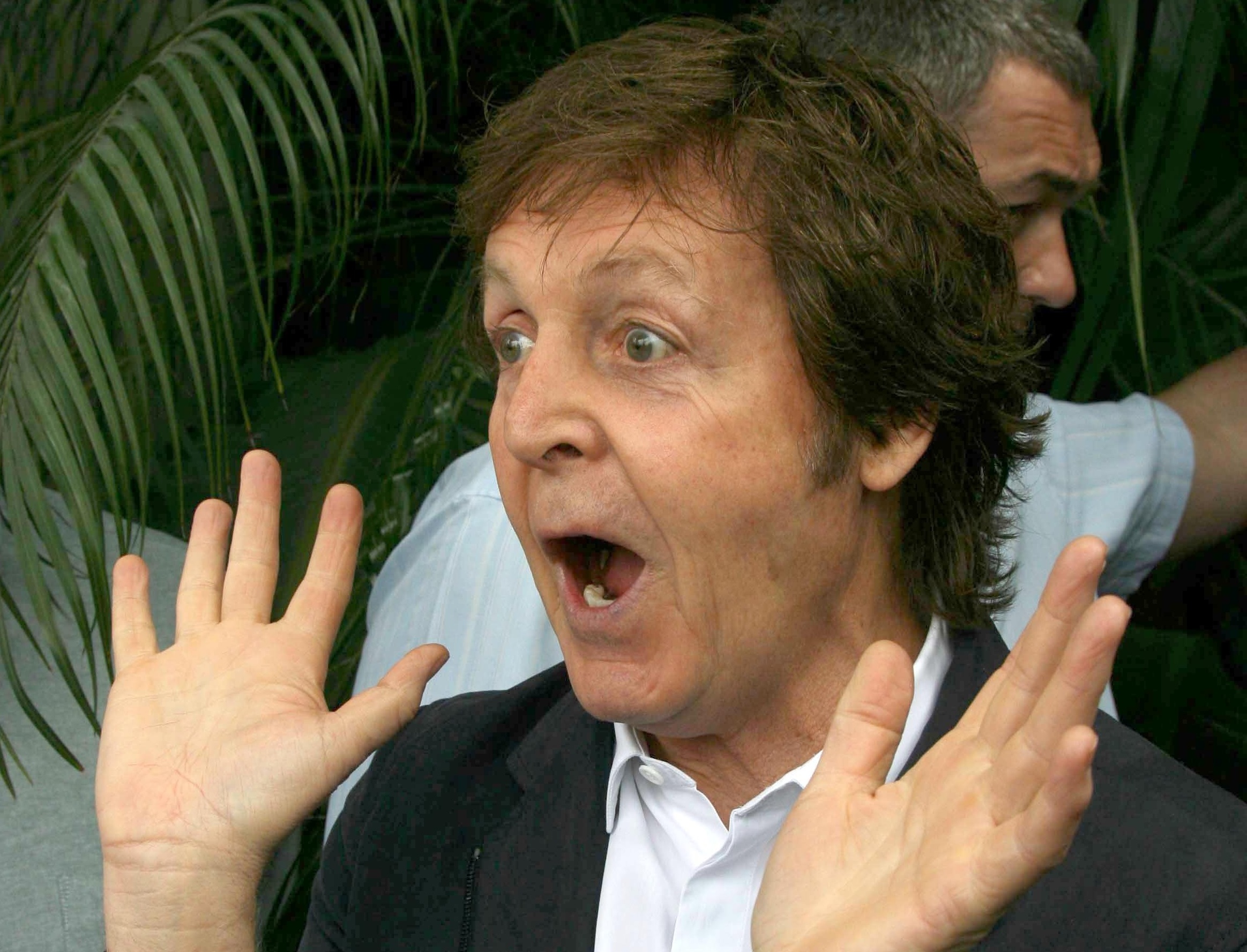 Paul McCartney wearing black suit and white shirt is making screaming face ,looking at people - 2009