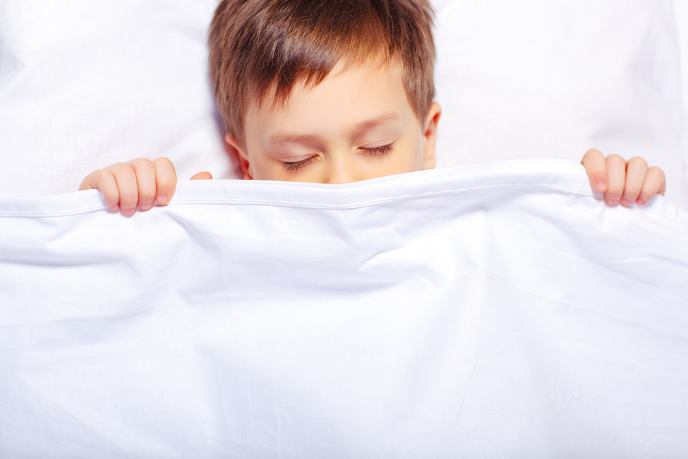 Top view of an adorable little boy sleeping in bed
