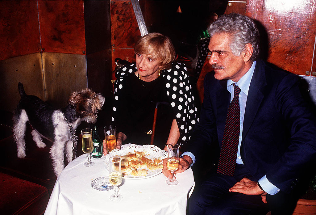 Omar Sharif in suit at restaurant looking left