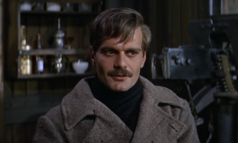 Omar Sharif in Doctor Zhivago in gray coat sitting on a chair