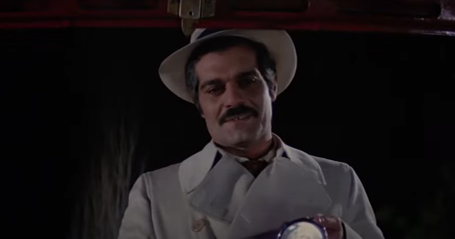 Omar Sharif in The Burglars wearing trench coat  and a hat