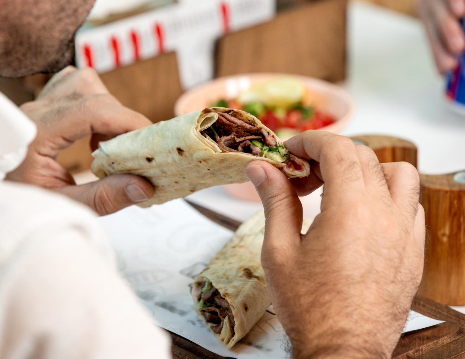 Man eating a burrito in restaurant.