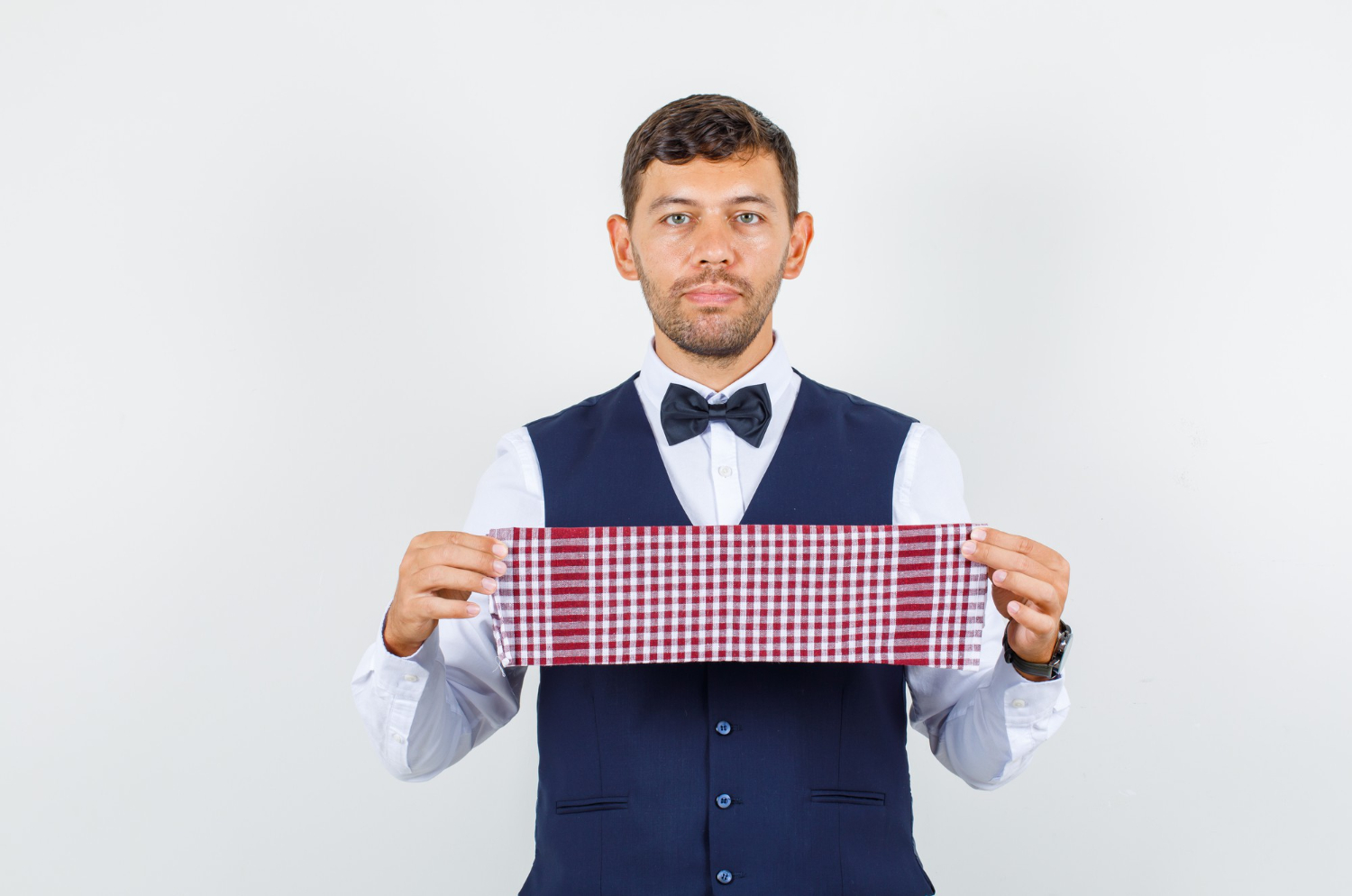 Waiter is holding a tablecloth with his hands and looking at camera.
