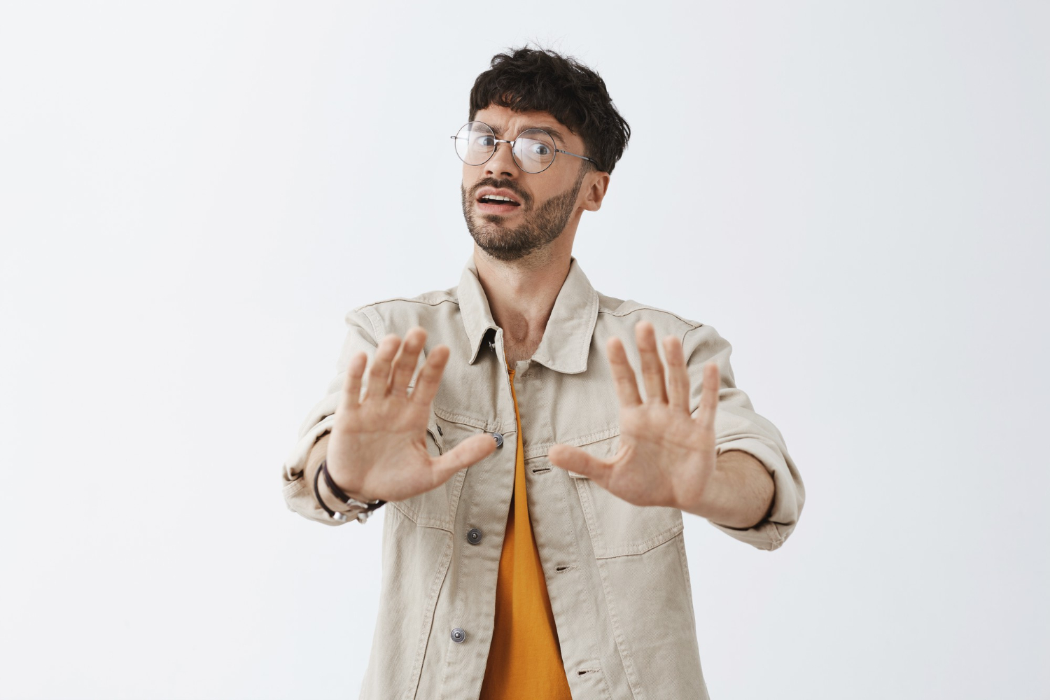 Man is making NO gesture with hand ,looking at camera.