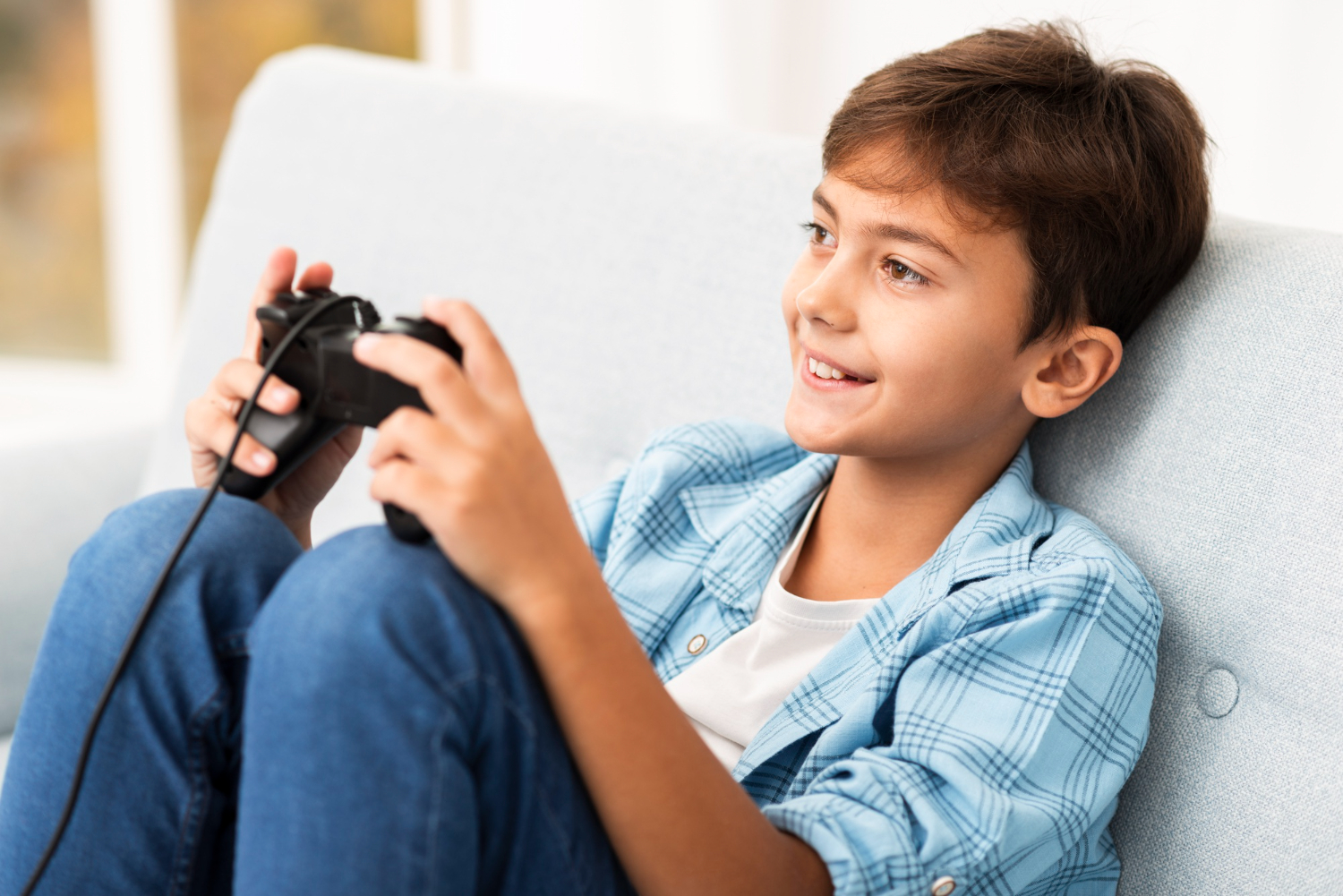 Kid is playing video game ,looking happy.