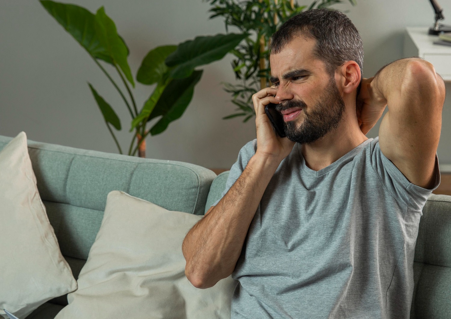 Man is talkin on the phone and making sad face.