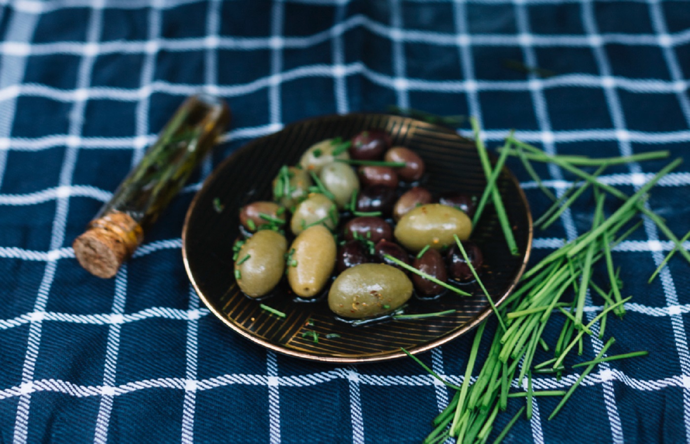 Olives in plate with oil and spices served at table.