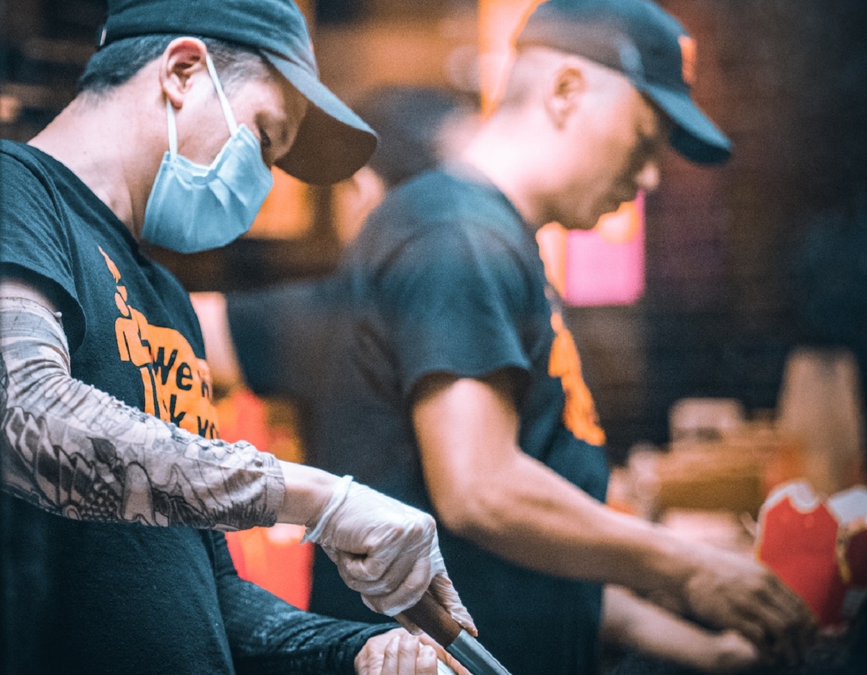 Men are preparing food in restaurant.