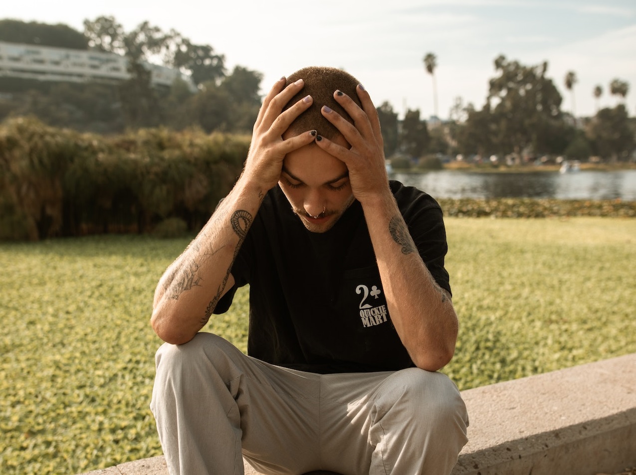 Young man is sitting and looking disappointed.