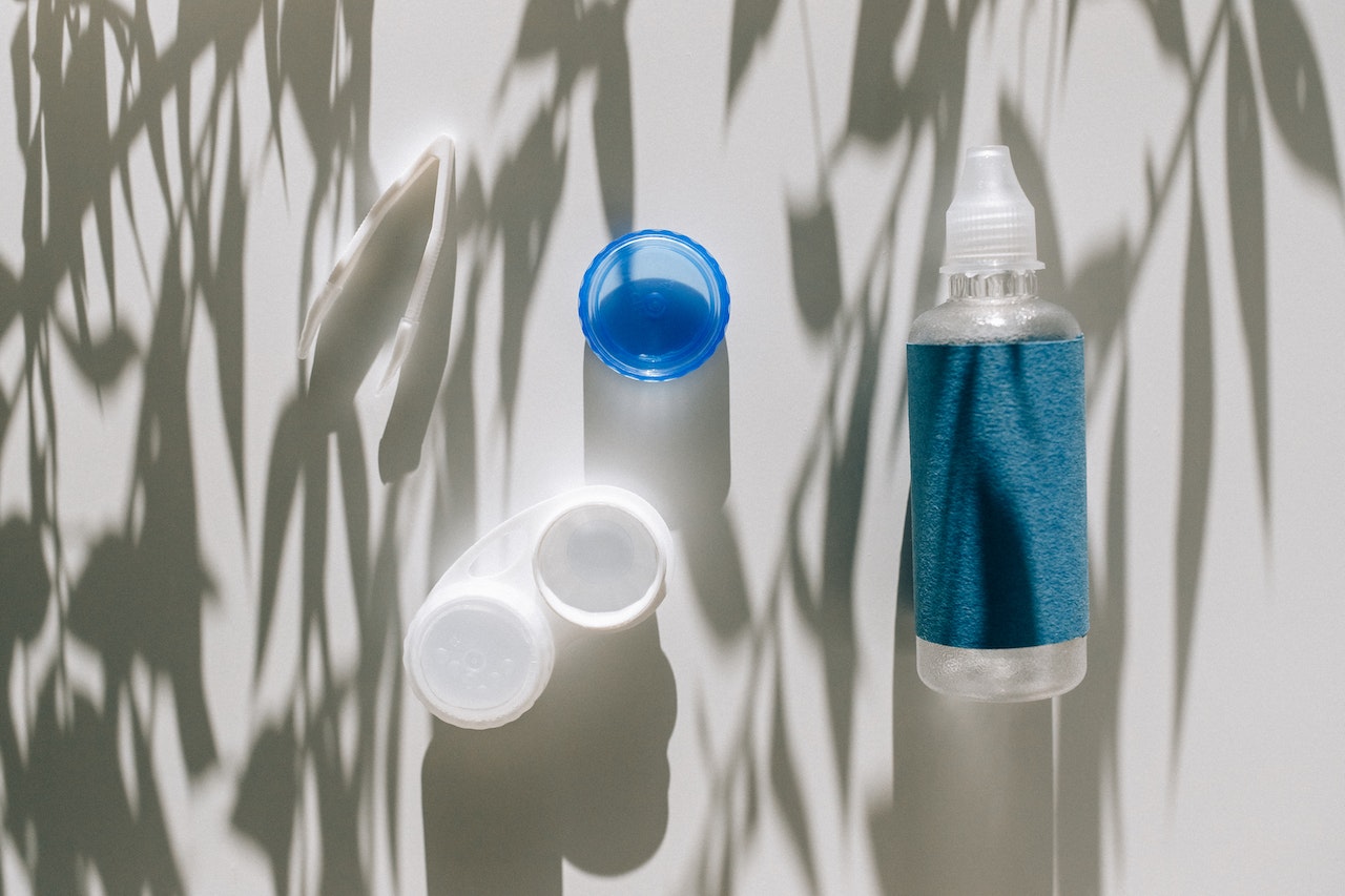 Contact lenses case and solution on a white table.