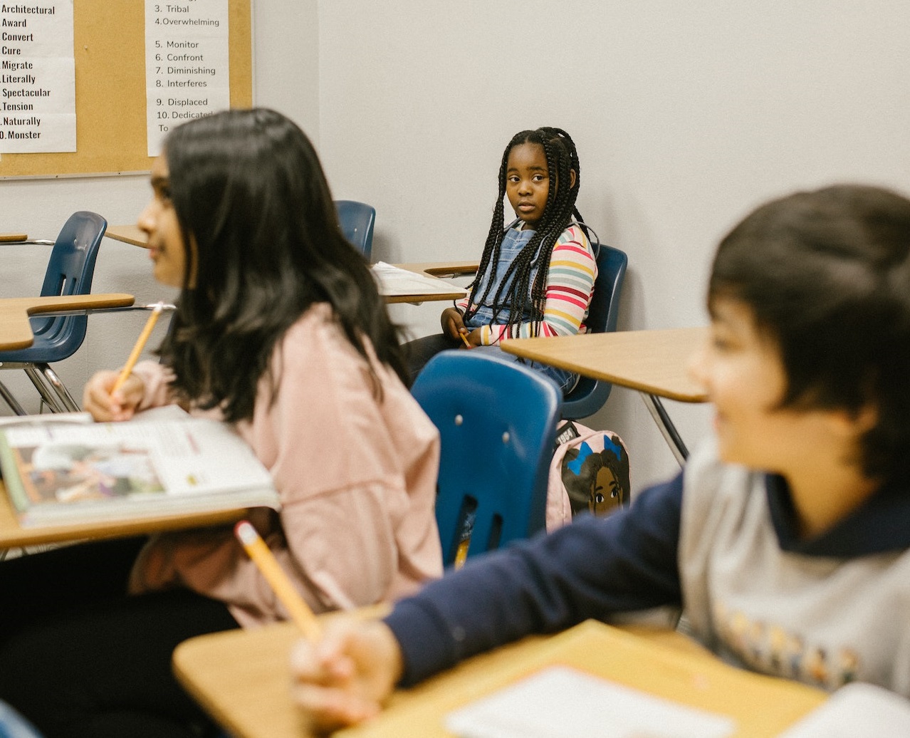Group of small kids are seating in classroom .