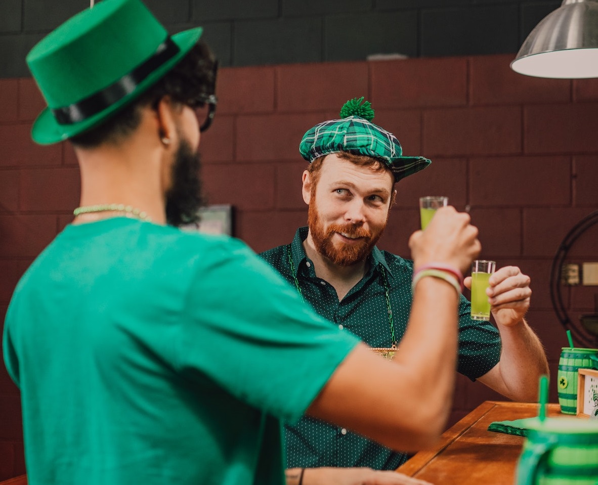 Men celebrating by drinking alcoholic drinks and making a toast .