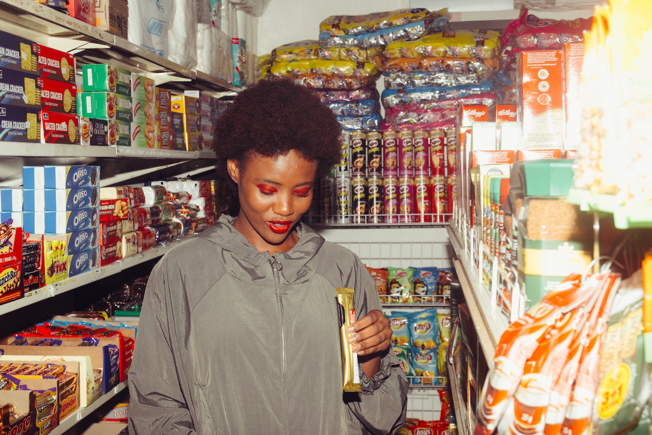 Woman is standing in grocery store looking down.