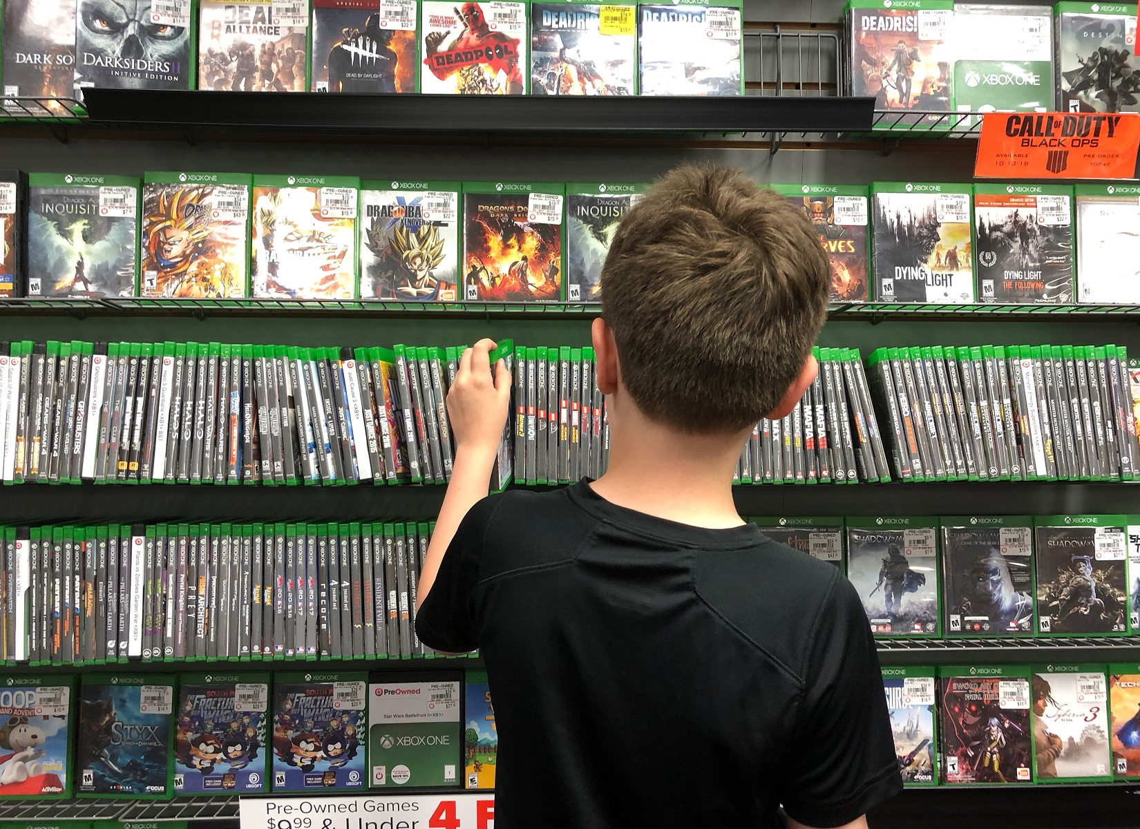 Kid is picking up game in videogame store.