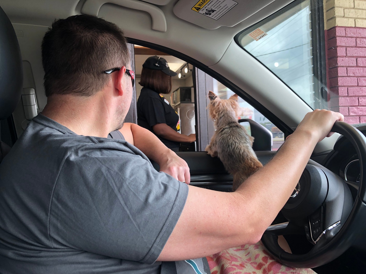 A man waits for KFC chicken at the drive thru window.