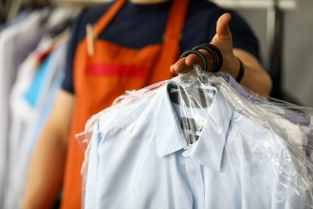 return clothes at store and employee in orange apron