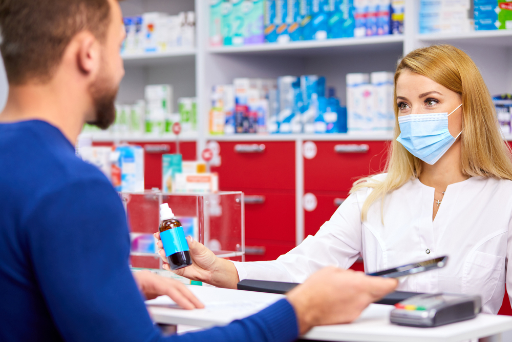 young professional pharmacist in uniform give medications
