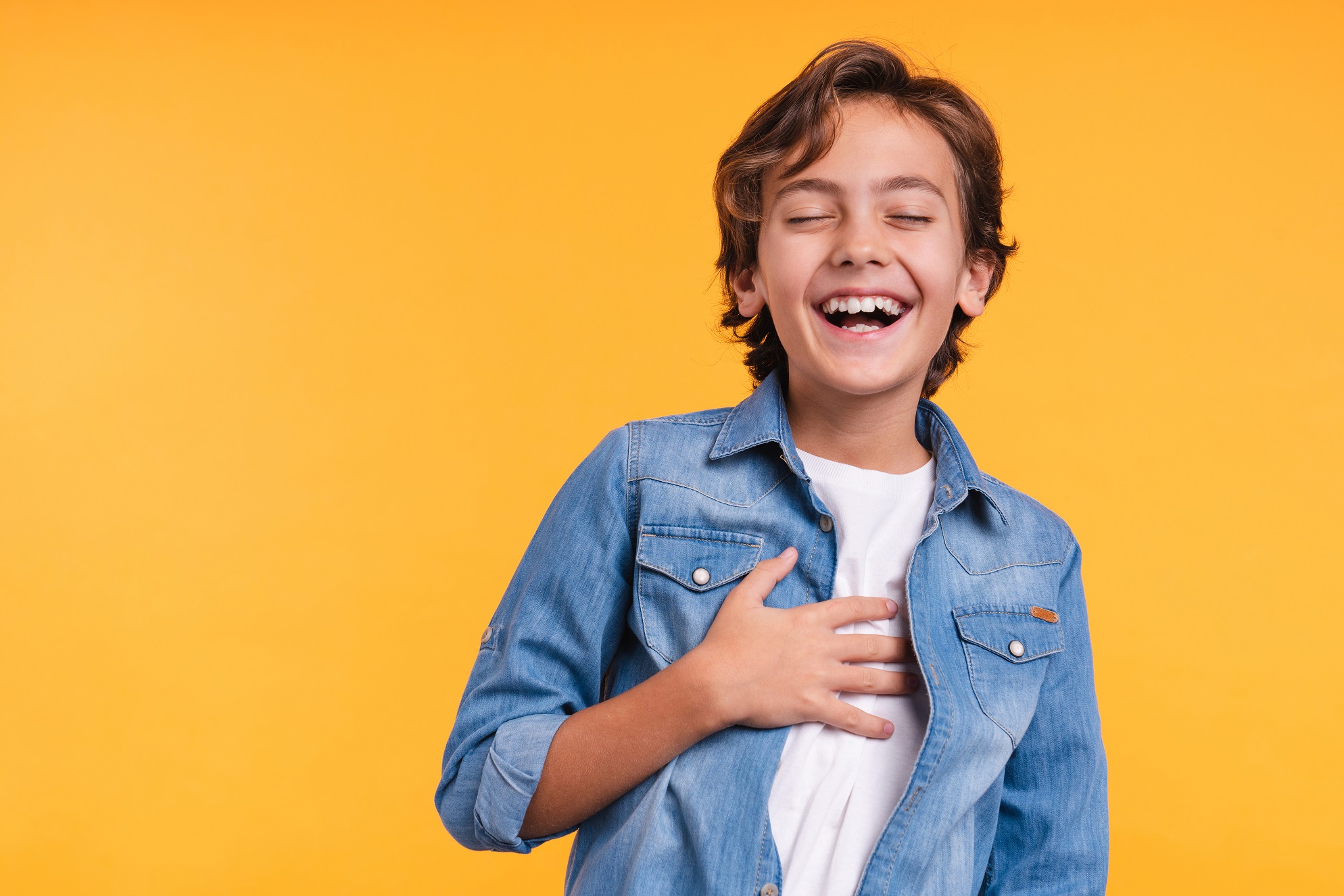 Kid is laughing in a yellow background.