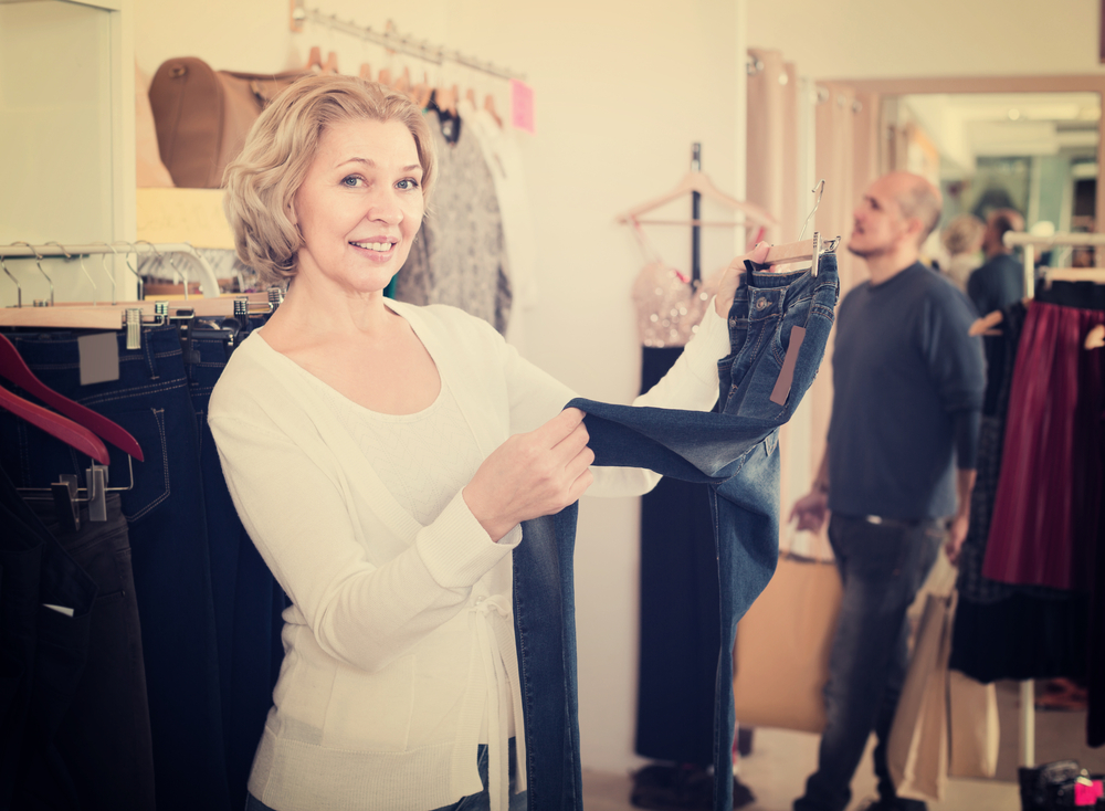 Older woman buying pants in white top