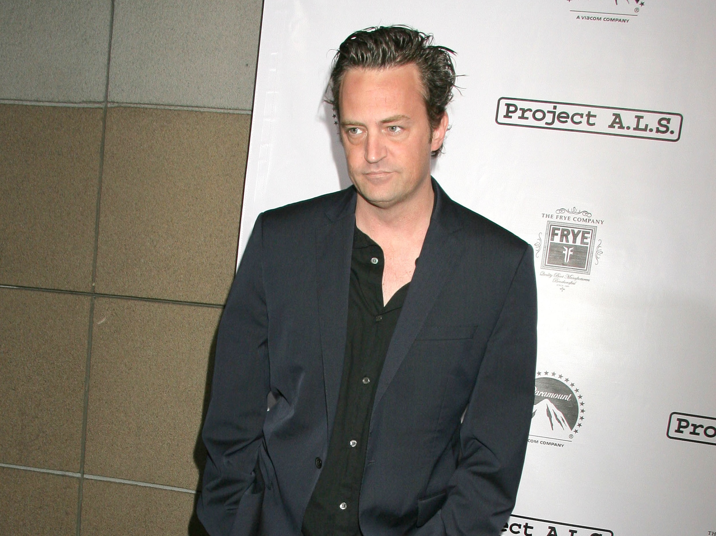 Matthew Perry wearing black shirt and jacket is looking messy - 2010