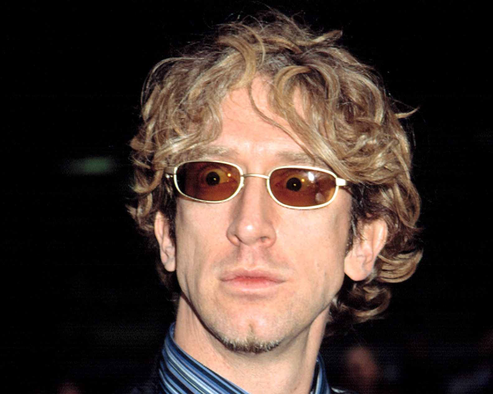 Andy Dick wearing sunglasses is looking at side surprised - 2002