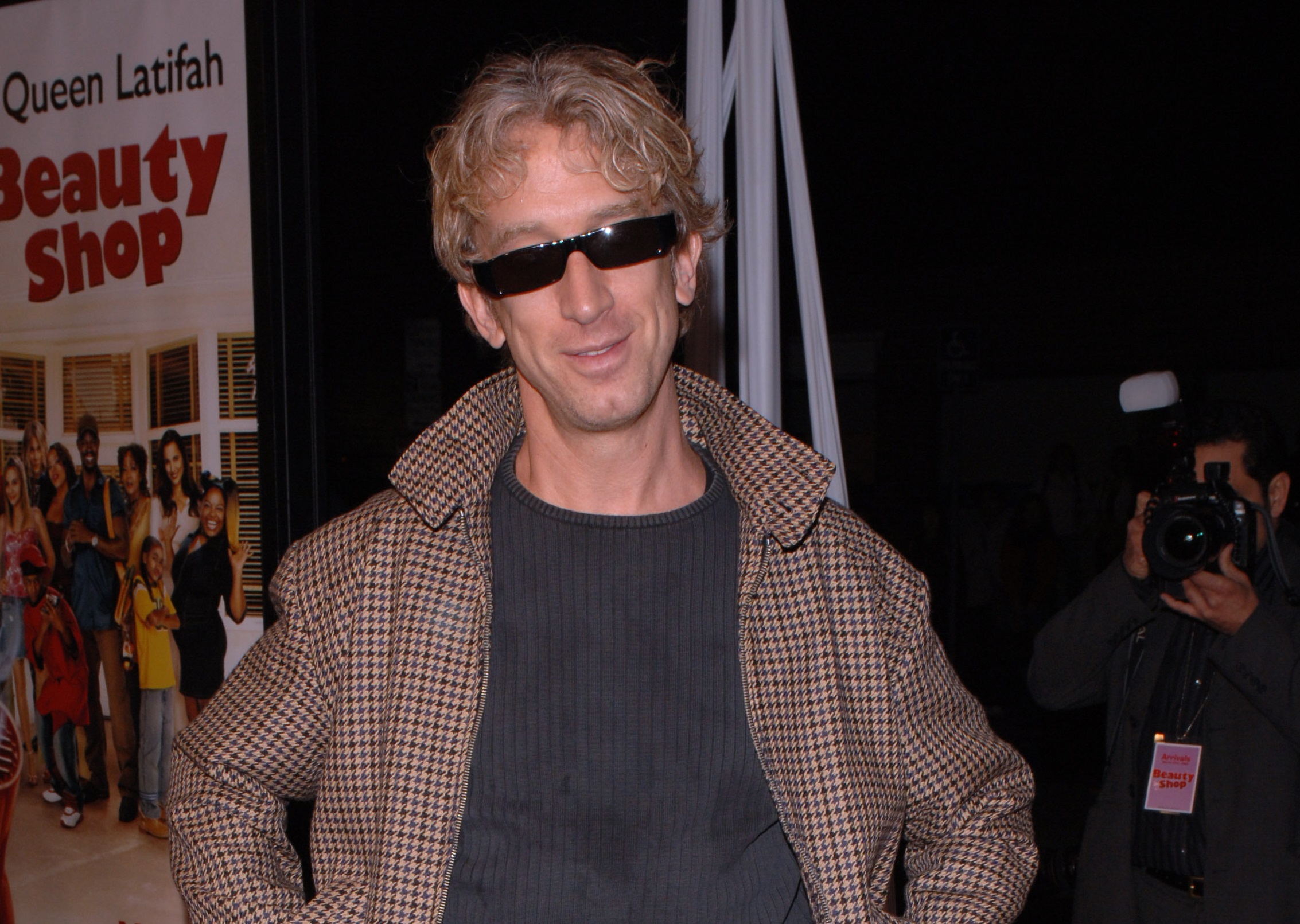 Andy Dick wearing black shirt ,brown jacket and black sunglasses is smiling and looking at camera - 2005