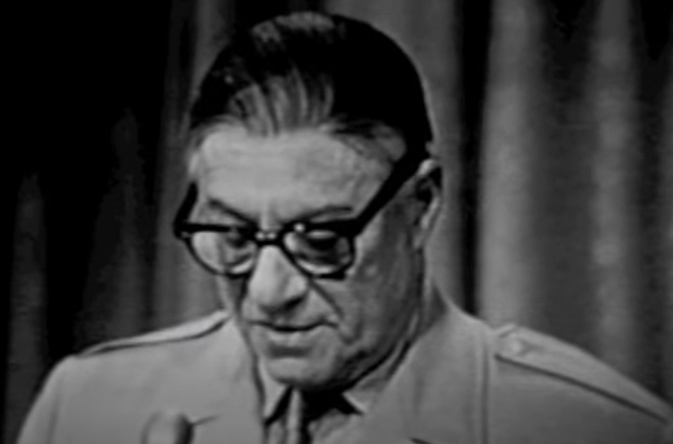 George Jessel in suit and tie wearing glasses