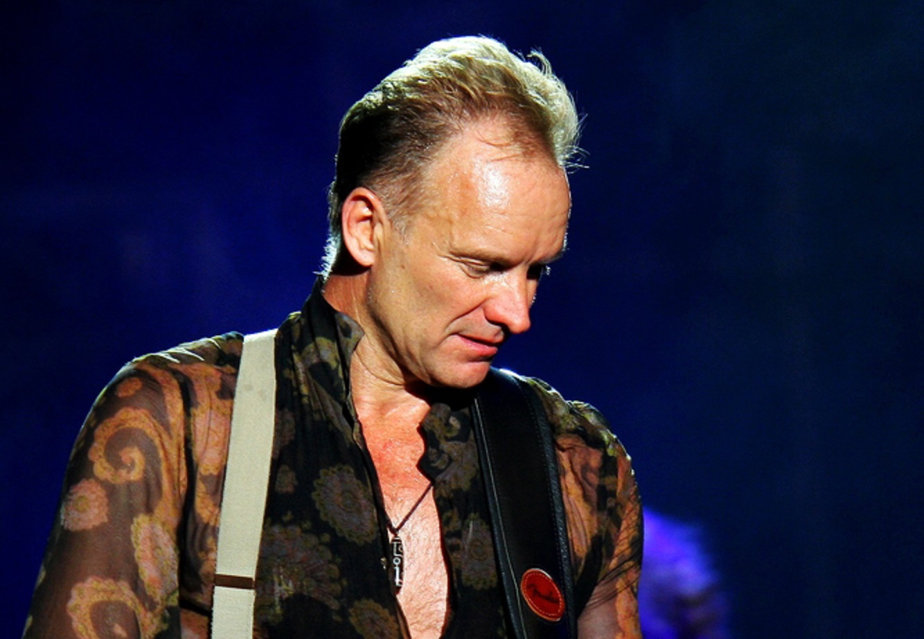 Sting is playing guitar on stage - 2010