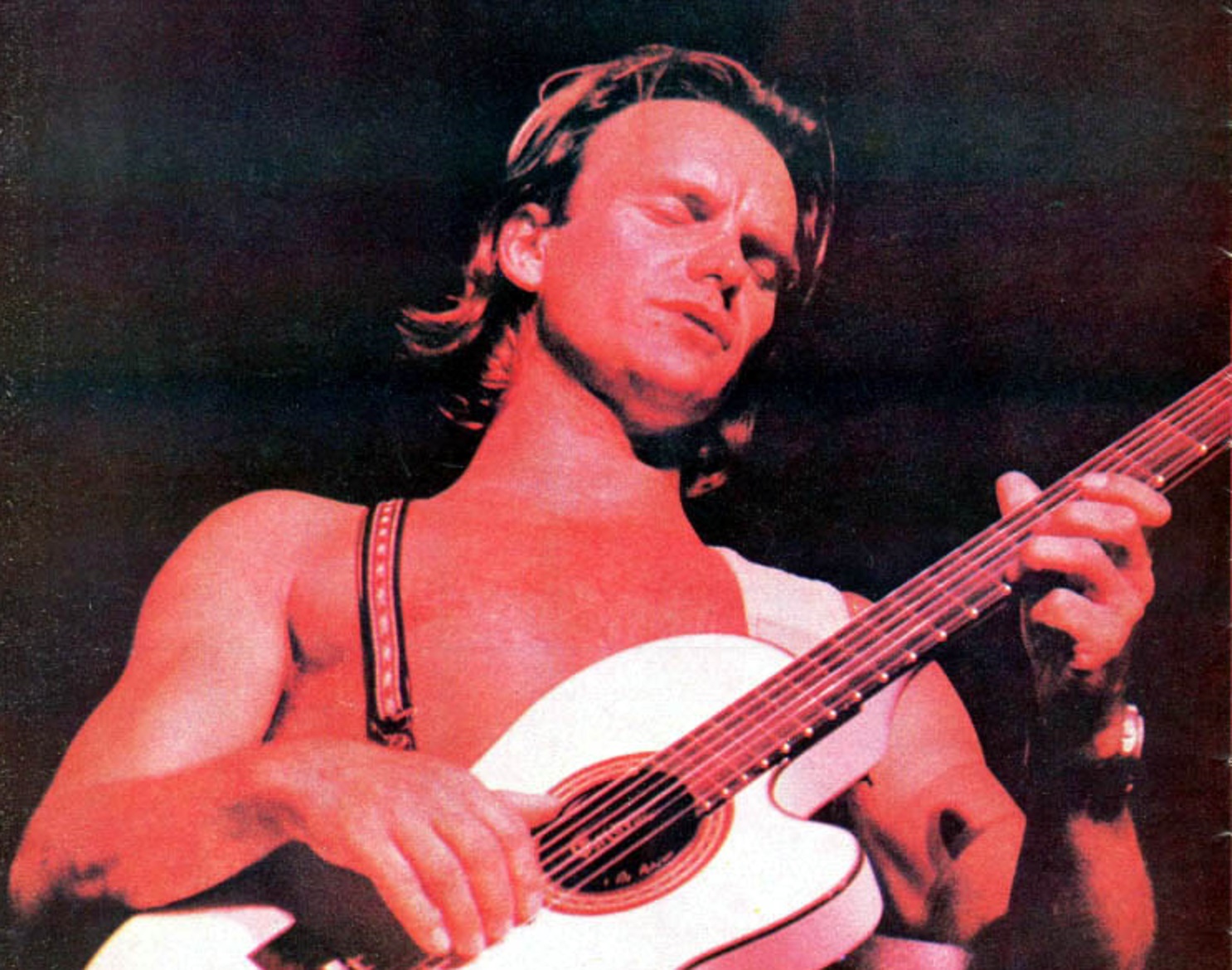 Sting playing an white acoustic guitar - 1987