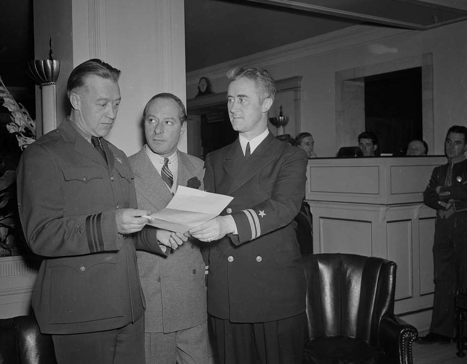 George Jessel standing between Lt. Commander Tom Collins and Lt. Joseph McDonough