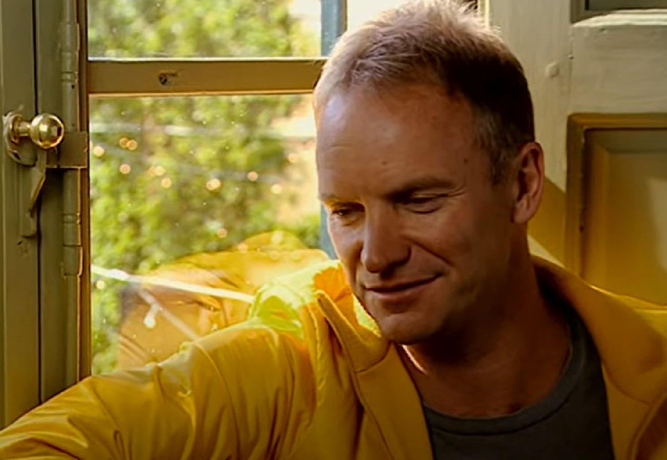 Screenshot: Sting looking down ,seating by the window  - from Sting-All This Time (2001)