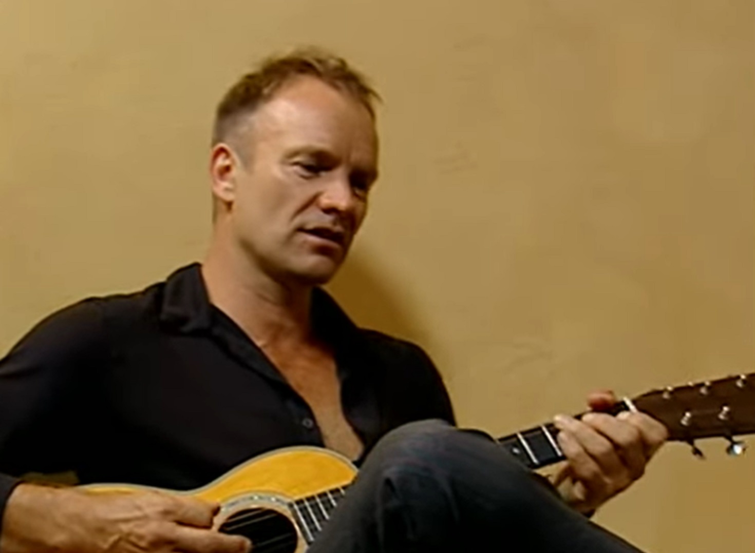 Screenshot: Sting is playing on guitar and singing - from Sting-All This Time (2001)