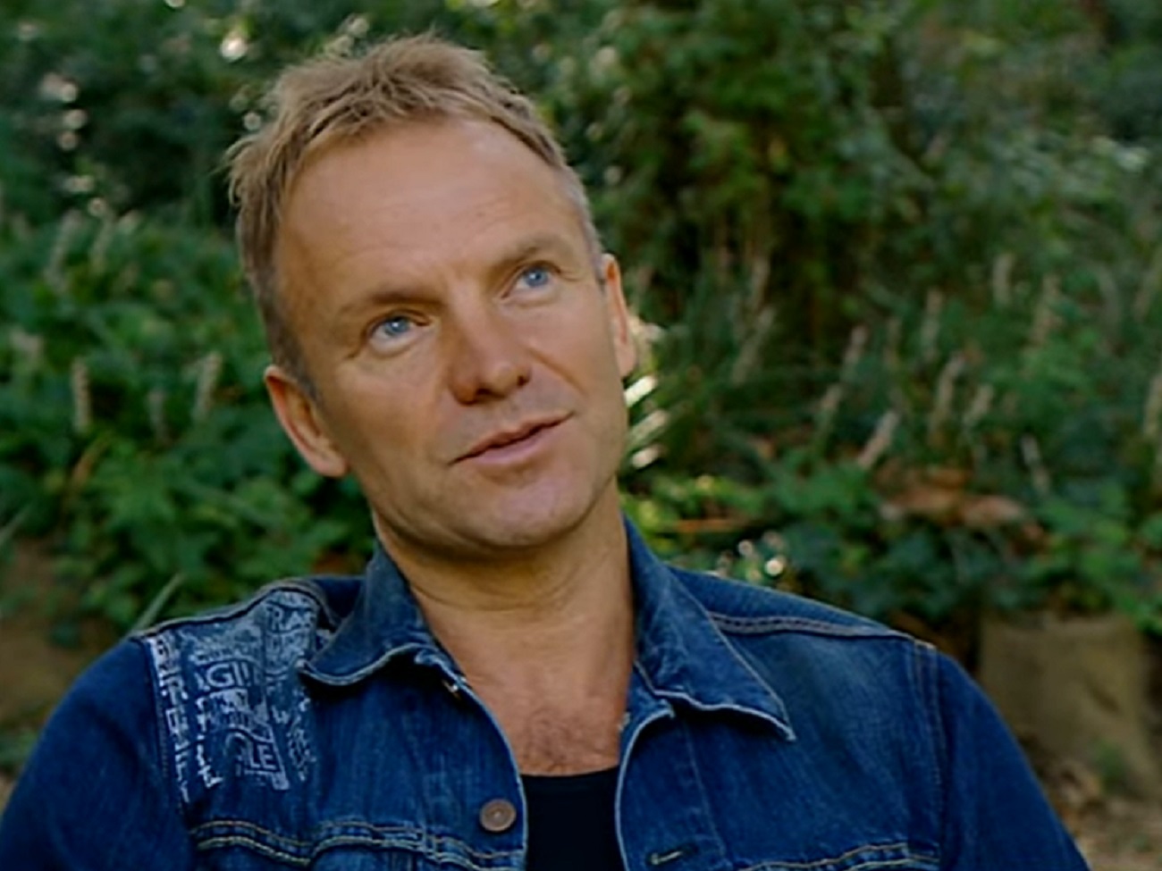 Screenshot: Sting wearing blue denim jacket looking up - from Sting-All This Time (2001)