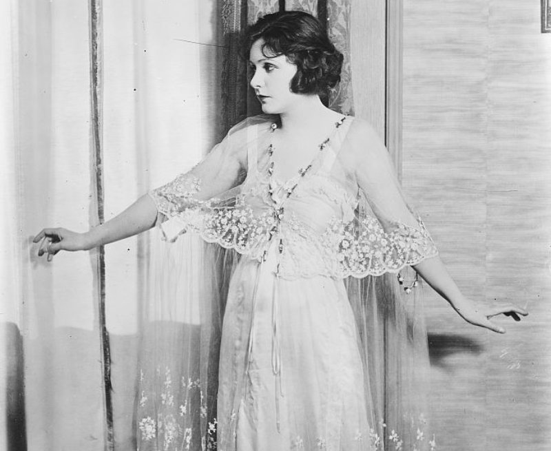 Norma Talmadge in white lace dress and jewels