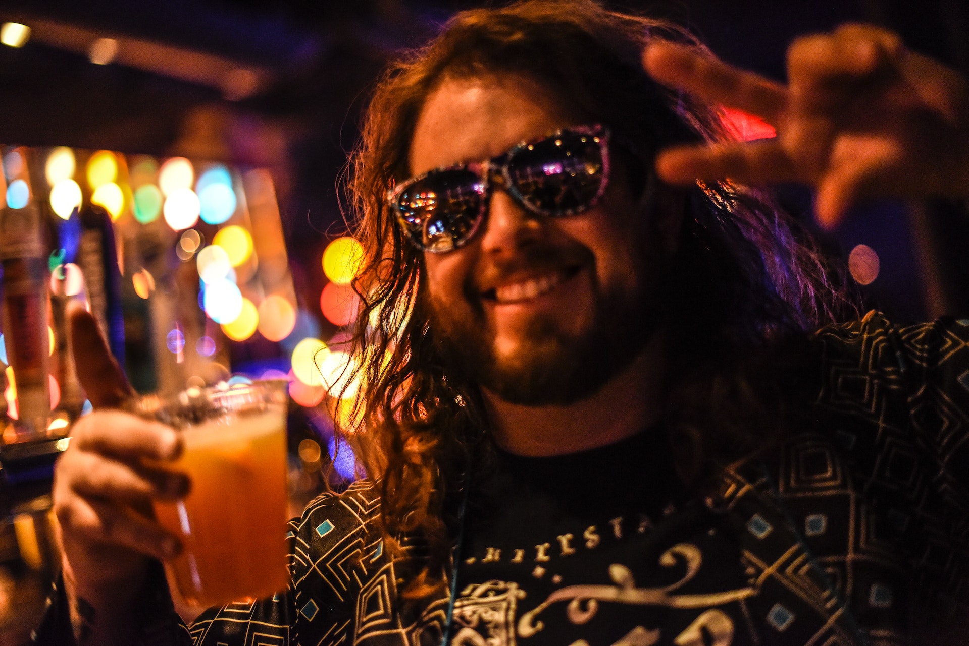 Man with long hair wearing sunglasses at a party