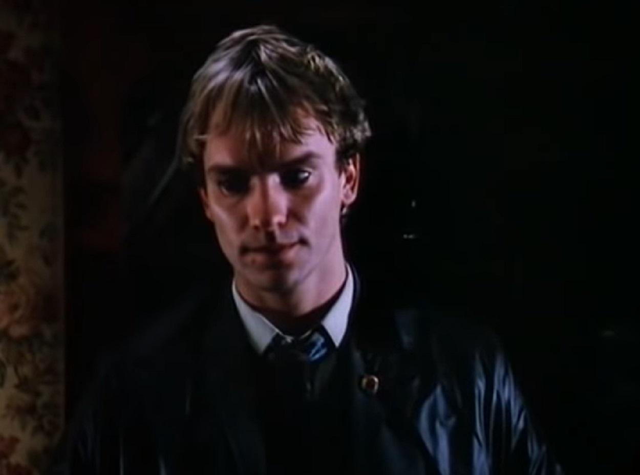 Screenshot: Sting wearing  black leather jacket and looking upset - from Brimstone & Treacle (1982)