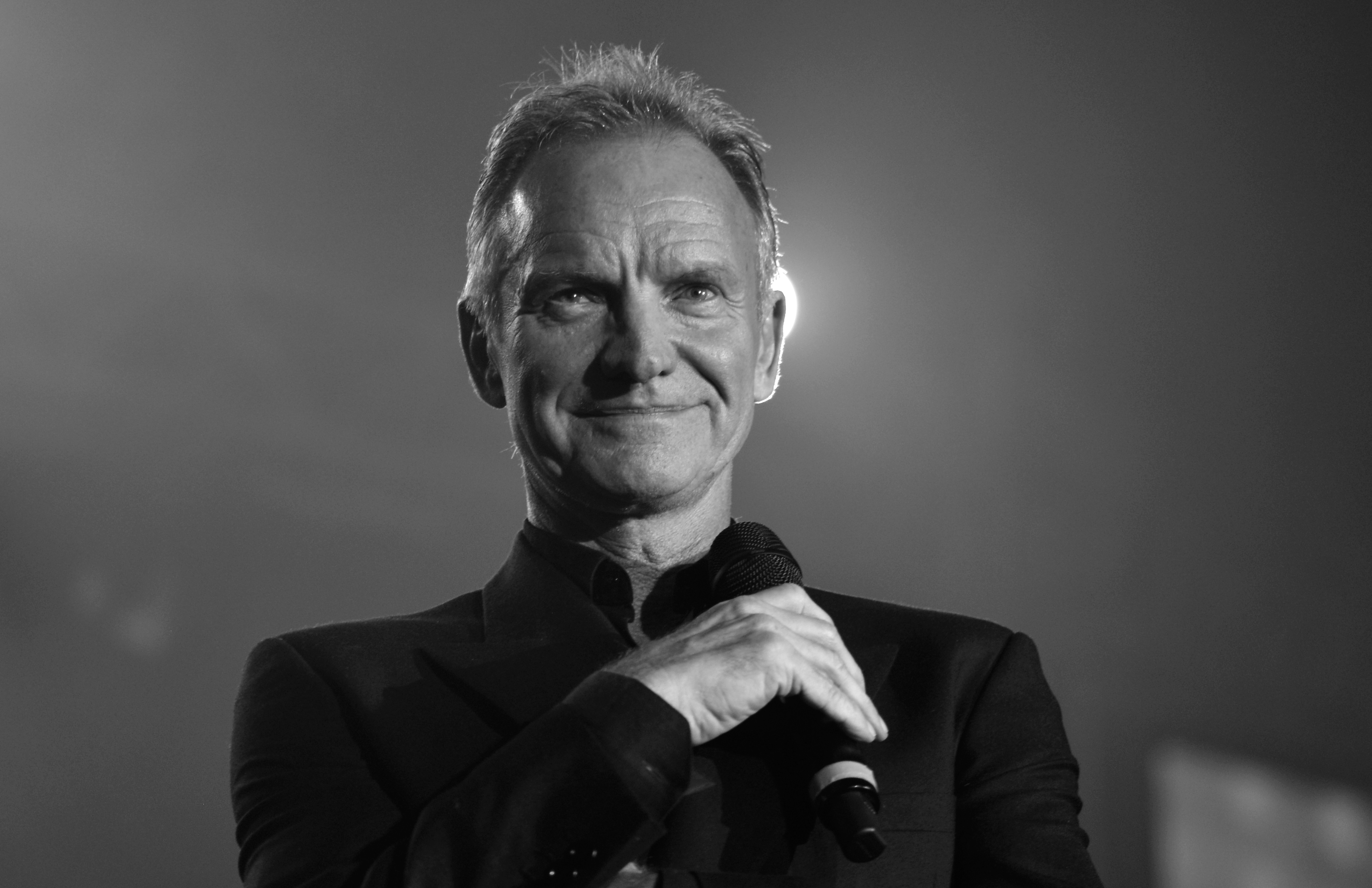B&W photo of Sting smiling and looking at front - 2019