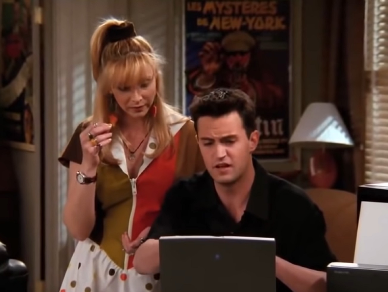 Screenshot: Matthew Perry is standing beside Lisa Kudrow and looking at laptop  - from Friends (1994-2004)