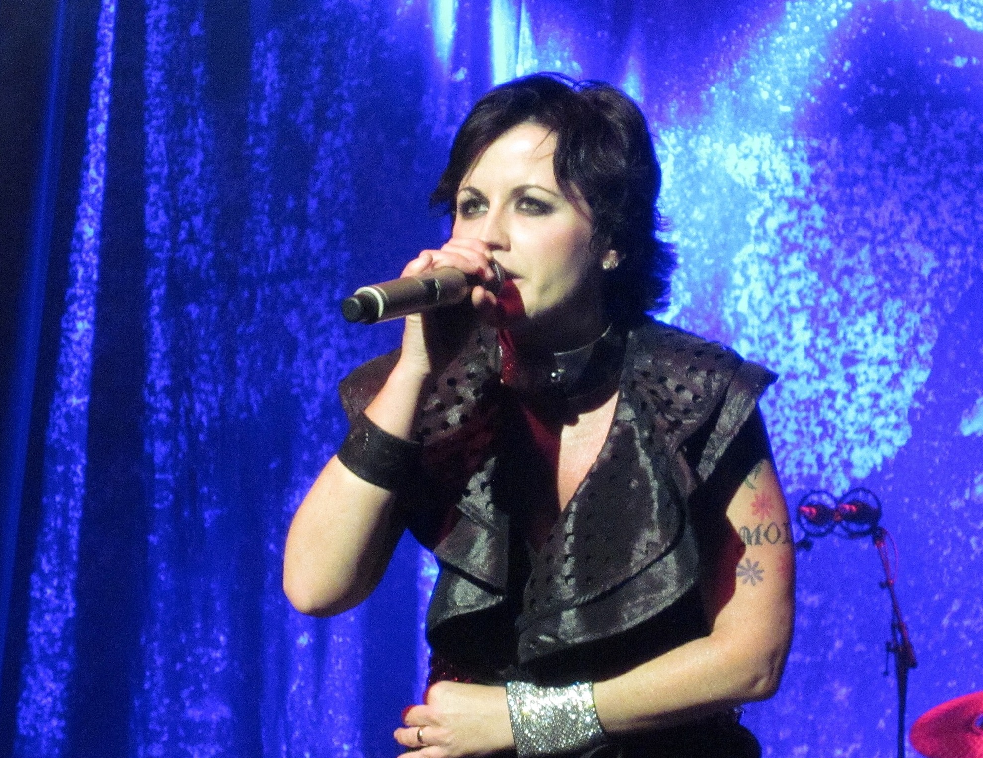 Dolores O'Riordan is performing live on stage ,looking at people - 2012