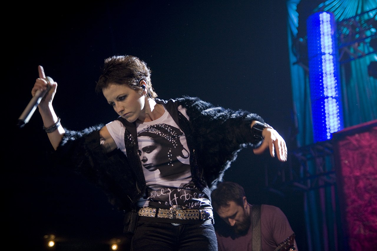 Dolores O'Riordan is making a hand gestures while performing live on stage - 2010